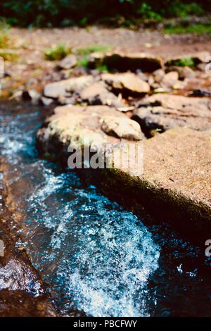 Wasser, das zwischen Felsen, Nandroya fällt, Atherton Tablelands, QLD, Australien Stockfoto