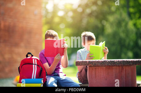 Kinder mit Rucksäcken stehen im Park in der Nähe von Schule Stockfoto