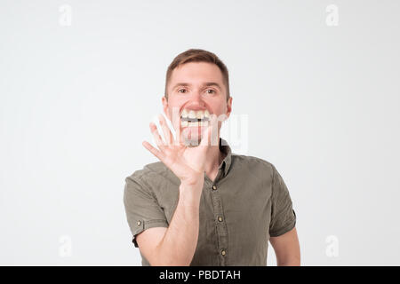 Europäischer Junger stattlicher Mann mit Lupe und seine Zähne zeigen. Stockfoto