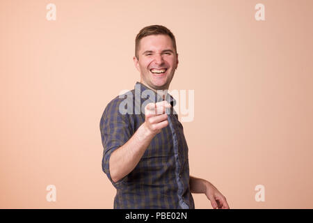 Porträt der europäischen jungen Mann, Lachen, zeigt mit dem Finger auf jemanden. Stockfoto