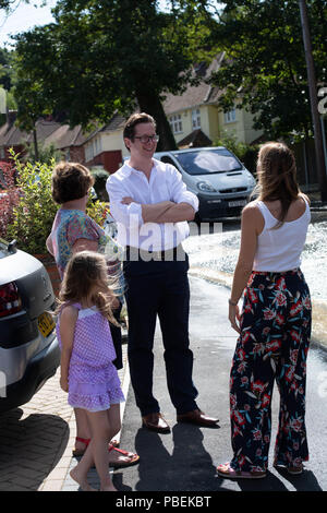 Essex, UK. 28. Juli 2018 Brentwood Essex, eine Wasserleitung platzte in Brentwood Essex Ursachen Überschwemmungen und Straße Chaos, lokale MP Alex Burghart (mit Brille) besucht die Szene Hilfe zu leisten. Kredit Ian Davidson/Alamy leben Nachrichten Stockfoto