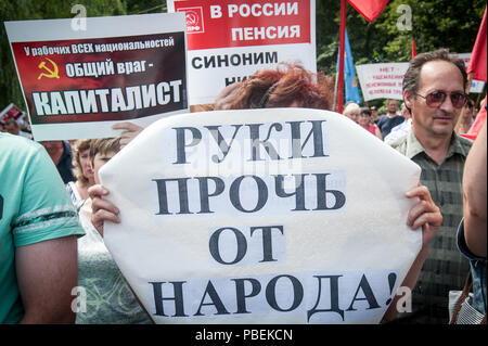 Tambow, Tambow, Russland. 28. Juli 2018. Am 28. Juli 2018 in vielen Städten Russlands fand der russischen Protest gegen die Rentenreform (Anhebung des Rentenalters). In der Stadt Tambow die Sitzung, zu der die Tambow Zweig der Kommunistischen Partei organisiert wurde. Etwa 1000 Menschen an der Kundgebung teil. Die Inschrift auf dem Plakat: (im Vordergrund) "Hände weg vom Menschen'', (hinten, links)'' Arbeiter aller Nationalitäten haben einen gemeinsamen Feind-kapitalistischen'' (hinten, rechts)'' in Russland, pension ist gleichbedeutend mit Armut. Credit: Alexey Sukhorukov/ZUMA Draht/Alamy leben Nachrichten Stockfoto