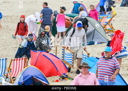 Lyme Regis, Dorset, Großbritannien. 28. Juni 2018. UK Wetter. Urlauber, die Verpackung den Strand zu verlassen, da der Regen beginnt in den Badeort Lyme Regis am ersten Tag der Hauptversammlung der Stadt RNLI lifeboat Woche an einem kühlen, windigen Tag. Foto: Graham Jagd-/Alamy leben Nachrichten Stockfoto