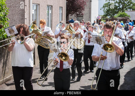 Wales, Großbritannien. 28. Juli 2018. Llansaint Karneval. Grand Carnival Parade. Dorf Veranstaltung. Carmarthenshire, Wales, Großbritannien Jährliche Veranstaltung im Juli statt. Parade wurde in der Sonne gehalten, nur die Vermeidung der sehr heftiger Regenschauer, die in ein paar Minuten vor fiel. Die Veranstaltung hatte Musik von lokalen Blaskapelle Crwbin und Fancy Dress Teilnehmer enthalten 'Rocket Man', maskierten Kim Jong-Un, Nordkoreanischer Führer. Credit: Paul Quayle/Alamy leben Nachrichten Stockfoto