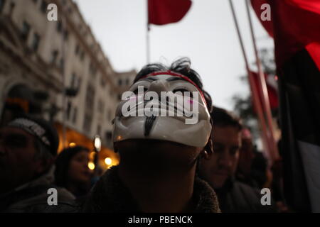 Lima, Peru. 27. Juli, 2018. Ein Mann mit einem Guy Fawkes nimmt Teil an einem Protest gegen die Korruption. Die Demonstranten fordern eine Reform der Justiz und Haftstrafen für Richter der Korruption beschuldigt. Der Protest in der peruanischen Hauptstadt führte zu Ausschreitungen zwischen der Polizei und Demonstranten. Der neueste Skandal in dem südamerikanischen Land kommt nur vier Monate nachdem Präsident Kuczynski zurückgetreten. Credit: Vitor Castellar/dpa/Alamy leben Nachrichten Stockfoto