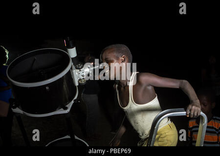 Kajiado County, Kenia. 27. Juli, 2018. Einen Kenianischen Jungen gesehen Blick durch ein Teleskop. Menschen die Mondfinsternis in Oloika Stadt, Magadi, Kenia Zeugnis. Der Mond vollständig abgedeckt Kernschatten der Erde in der Nacht vom 27. Juli 2018 für 103 Minuten, die das Eclipse die längste Mondfinsternis des 21. Jahrhunderts. Credit: Bonifatius Muthoni/SOPA Images/ZUMA Draht/Alamy leben Nachrichten Stockfoto