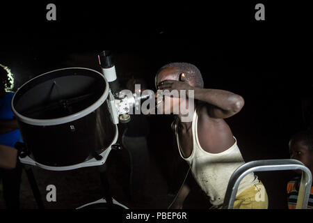 Kajiado County, Kenia. 27. Juli, 2018. Einen Kenianischen Jungen gesehen Blick durch ein Teleskop. Menschen die Mondfinsternis in Oloika Stadt, Magadi, Kenia Zeugnis. Der Mond vollständig abgedeckt Kernschatten der Erde in der Nacht vom 27. Juli 2018 für 103 Minuten, die das Eclipse die längste Mondfinsternis des 21. Jahrhunderts. Credit: Bonifatius Muthoni/SOPA Images/ZUMA Draht/Alamy leben Nachrichten Stockfoto