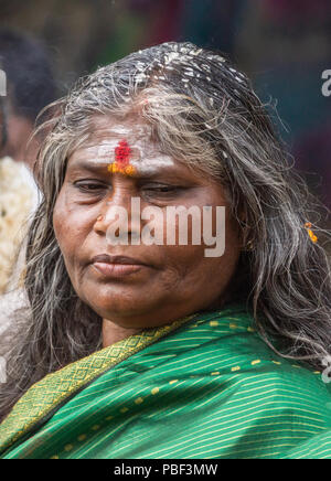 Belathur, Karnataka, Indien - November 1, 2013: Nahaufnahme von grünen Sari gekleidet Frau Abschied von Abfliegenden pilgirms während der Zeremonie. Reis Kernel Stockfoto