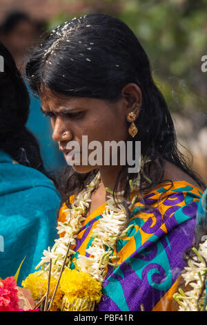 Belathur, Karnataka, Indien - November 1, 2013: Nahaufnahme von grünen Sari gekleidet Frau Abschied von Abfliegenden pilgirms während der Zeremonie. Reis Kernel Stockfoto