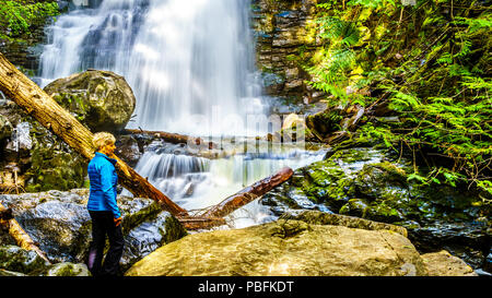 Ältere Frau an Whitecroft fällt, ein Wasserfall an McGillivray Creek und eine kurze Wanderung von Sun Peaks Road in der Nähe der Stadt Whitecroft in BC, Kanada Stockfoto