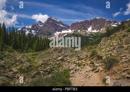 Majestic Maroon Bells Peaks von der rauen Crater Lake Trail gesehen an einem sonnigen Tag mit blauen Himmel im Sommer in der Nähe von Aspen, Colorado Stockfoto