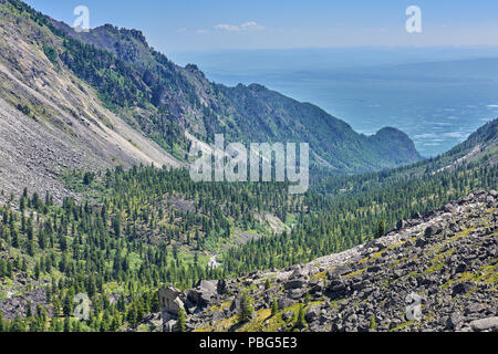 Berg Taiga in einem engen Tal und eine große Aue Tal mit vielen Seen im Hintergrund. Tunkinsky National Park. Republik Burjatien. Russland Stockfoto