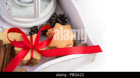 Weihnachtsplätzchen gebunden mit roter Schleife in einer Holzkiste. Platz für Text Stockfoto