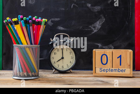 Zeit für die Schule. 1. September Datum, Wecker und Bunte Bleistifte auf blackboard Hintergrund Stockfoto