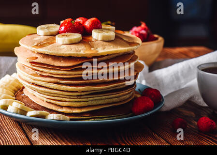 Hausgemachte Pfannkuchen mit Früchten. Bananenscheiben und gefrorenen Erdbeeren. Stockfoto