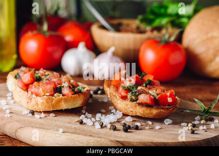 Klassische Bruschetta mit Tomaten und Zutaten auf Hintergrund Stockfoto