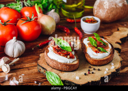 Zwei Bruschetta mit getrockneten Tomaten und würziger Sauce mit Chili Stockfoto