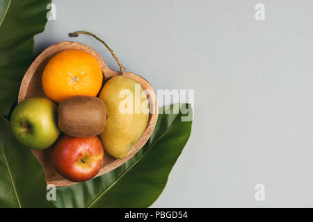 Orange, Mango, Apfel und Kiwi in einem hölzernen herzförmige Platte Stockfoto