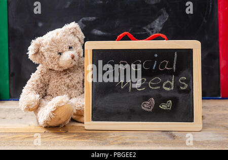 Besondere Bedürfnisse in der Schule. Teddybär hinter einer Tafel versteckt. Besondere Bedürfnisse text Zeichnung an der Tafel Stockfoto