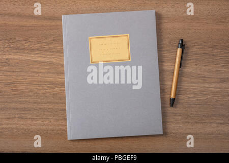 Grau School Notizbuch oder Tagebuch, altmodisch, und Pen isoliert auf hölzernen Schreibtisch, leeres Etikett, Platz für Text, Ansicht von oben Stockfoto