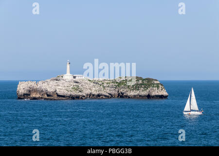 Santander, Spanien. Blick auf die Isla de Mouro (Mouro Insel) von der Magdalena Halbinsel in Kantabrien, mit einem kleinen Segelschiff im Vordergrund. Stockfoto