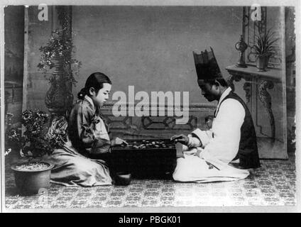 Über ein Spiel (gehen). Mann und Frau auf dem Boden spielen Spiel an Bord sitzen. 1910-1920 Stockfoto