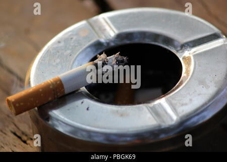 Nahaufnahme des gerauchten Zigarette im Aschenbecher aus Edelstahl Stockfoto