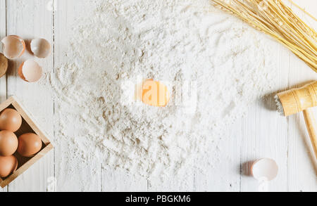 Hintergrund mit Kuchen backen Zutaten auf weißem Holz von oben Schüssel Mehl Eier Stockfoto