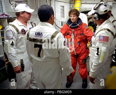 Mission STS-114 die Kommandantin Eileen Collins wird durch die Closeout Crew mit ihr starten und Eintrag Klage vor dem Betreten Space Shuttle Discovery geholfen. Stockfoto