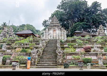 Balinesische Frau in kebaya und sarong verlassen Angebote im Pura Kehen, balinesischen Hindu Tempel in Bangli Regency, Bali, Indonesien Stockfoto