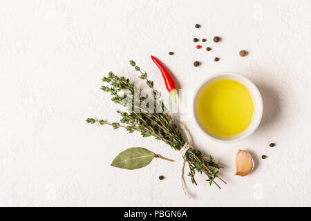 Olivenöl und Strauß Thymian auf einen weissen Stein Hintergrund. Stockfoto