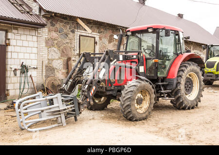 Traktor mit hydraulischen Aufzug für den Transport von Heu und Silage. Foto eines allgemeine Ansicht einer landwirtschaftlichen Maschine. Die Ausrüstung für eine Molkerei. Stockfoto