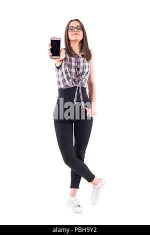 Tausendjährige hipster junge Teenager Frau, leeren Bildschirm des Smartphones an der Kamera. Voller Körper auf weißem Hintergrund. Stockfoto