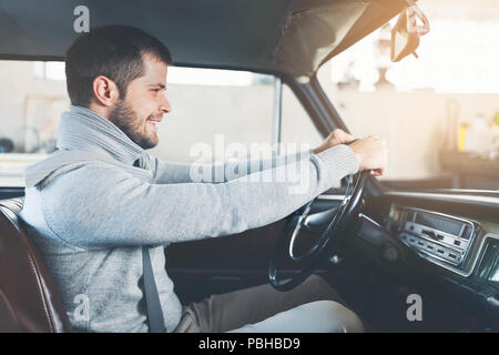 Schöner Mann in seinem alten Oldtimer sitzen Stockfoto