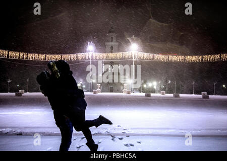 Verschwommene oder Defokussierten Bild des Paares ist Küssen vor dem Hintergrund der Lichter der Nacht verschneite Stadt und das Neue Jahr Stockfoto