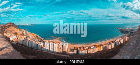 Alicante Panoramablick auf den Strand Postiguet von der Burg Santa Barbara. Es ist eine berühmte touristische Stadt in Costa Blanca, Spanien. Blaugrün und Orange Stil. Stockfoto