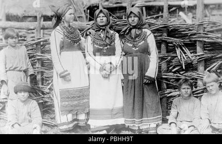 Fotos zeigen drei alte Frauen in kulturellen Kleid stand vor der Gebäude und die vier Jungs vor Zaun anmelden. Russland 1880-1924 Stockfoto