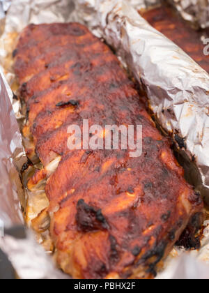 Schweinerippchen mit Barbecue Sauce gebackene in Aluminiumfolie Nahaufnahme Stockfoto