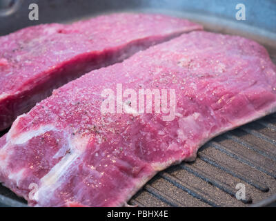 Erfahrene rohes Rindfleisch Flank Steak auf heißem Kochen pan Stockfoto