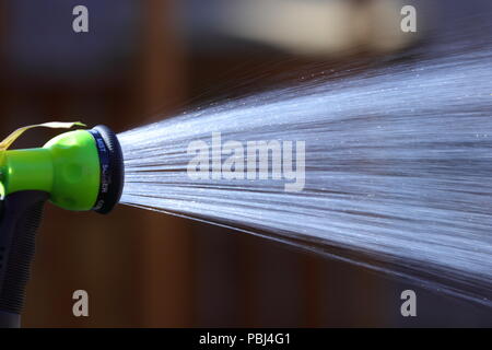 Eine Dusche von Wasser aus einem Gartenschlauch, bevor die vorgeschlagenen Gartenschlauch Verbot in Kraft tritt. Stockfoto