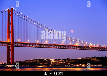 Blick auf die Mondfinsternis, die längste Blut Mond des 21. Jahrhunderts, über die Brücke des 25. April in Lissabon, Portugal Stockfoto