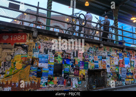 Seattle, Washington - 30. Juni 2018: Bunte zerrissene Plakate auf grunge alten Mauern am Pike Place Market in Seattle. Stockfoto