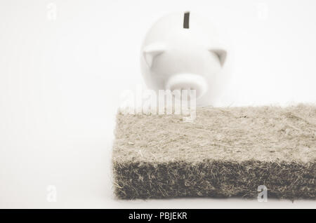 Terrakotta piggy Bank- und Wanddämmung Panel auf einem weißen Hintergrund - Energiesparkonzept Stockfoto