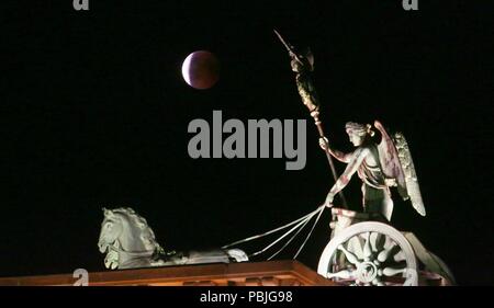 Berlin, Deutschland. 27. Juli, 2018. Für eine Stunde und 43 Minuten, der Mond ist völlig in den Schatten der Erde versenkt. Der Mond erscheint dann als rötliche Scheibe am Himmel. Das Foto zeigt den Mond über dem Brandenburger Tor. Quelle: Simone Kuhlmey/Pacific Press/Alamy leben Nachrichten Stockfoto
