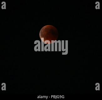 Berlin, Deutschland. 27. Juli, 2018. Für eine Stunde und 43 Minuten, der Mond ist völlig in den Schatten der Erde versenkt. Der Mond erscheint dann als rötliche Scheibe am Himmel. Das Foto zeigt den Mond über dem Brandenburger Tor. Quelle: Simone Kuhlmey/Pacific Press/Alamy leben Nachrichten Stockfoto