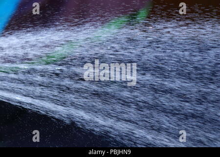 Eine Dusche von Wasser aus einem Gartenschlauch, bevor die vorgeschlagenen Gartenschlauch Verbot in Kraft tritt. Stockfoto