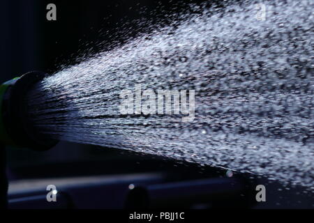 Eine Dusche von Wasser aus einem Gartenschlauch, bevor die vorgeschlagenen Gartenschlauch Verbot in Kraft tritt. Stockfoto