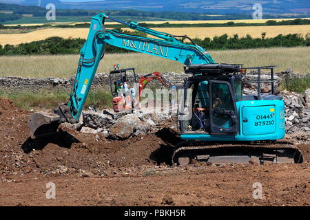 Große gegen Kleine in den Anlagen, Maschinen, zwei Bagger bei der Arbeit in einem Feld wiederhergestellt wird nach Abschluss der Bauarbeiten zu Ackerland. Stockfoto