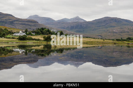 Die Berge von Wester Ross in den westlichen Highlands von Schottland spiegeln sich im ruhigen Meerwasser des Loch Torridon. Stockfoto