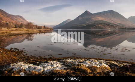 Die markante Form Pap von Glencoe Mountain ist in den ruhigen Wasser des Loch Leven, einem fjordähnlichen Bucht des Atlantischen Ozeans, die auf einem klaren Wint wider Stockfoto